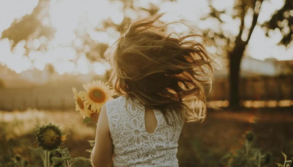 a woman holding sunflowers in a field